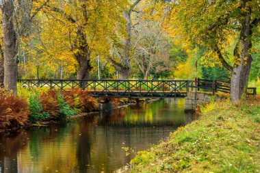 İsveç 'te Stromshoms kanalı canlı sonbahar renklerinde, burada teknelerin geçmesine izin veren geri çekilebilir bir köprü var.