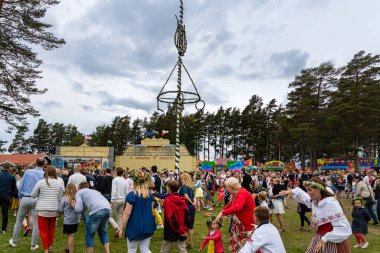 Orsa, İsveç, 23-06-2017. Yaz ortası direğinin etrafında dans eden insanlar midummer 'ı geleneksel İsveç usulü kutluyorlar.