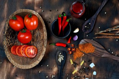 kırmızı biber ve domates, tuz, sarımsak, koyu ahşap zemin üzerinde biberiye; yemek yapmak için malzemeler; yemek kitabını kaplamak; Asya mutfağı, yazı için serbest alan