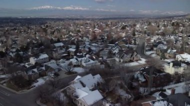 4K İHA görüntüsü caddelerin yukarısından, araba ve evlerle, uzaktaki Karlı Dağlar, şehir sokakları, Utah Mahallesi, Utah Eyaleti, Slc, Provo, Orem Mormon Kültürü ile çekildi.