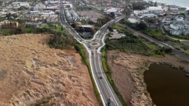 Güney Kaliforniya 'da okyanus kıyısında 4K hava aracı görüntüsü. Mavi Pasifik Okyanusu' ndan dalgalar geliyor ve arka planda güzel evler var. Bir lagünün havadan görünüşü. 