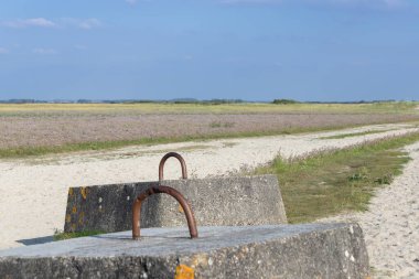 Bir patika boyunca ve mavi gökyüzünün altında beton bloklar