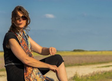 Güzel olgun kadın doğada poz veriyor.