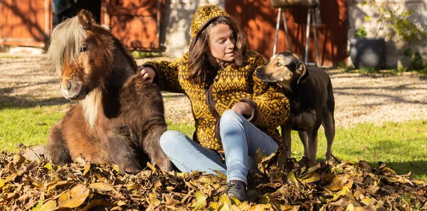 Jeune Femme Assise Dans Des Feuilles Mortes Avec Son Poney — Photo