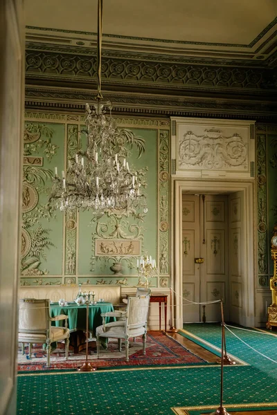 Vranov nad dyji, Güney Moravya, Çek Cumhuriyeti, 03 Temmuz 2021: Kale içi, barok ahşap oyma mobilya, yeşil misafir salonu, boyalı duvarlar, masada porselen servis, kristal avize.