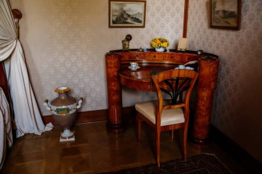 Lednice, Güney Moravya, Çek Cumhuriyeti, 04 Temmuz 2021: Barok ahşap oymalı mobilyalar, yatak odasının yanındaki halının üzerine yazı masası ve sandalye, güzel UNESCO şatosu.