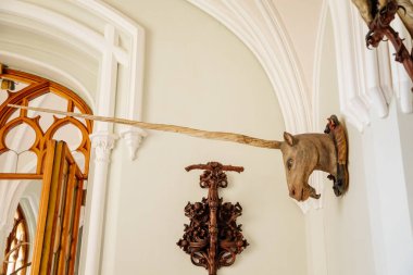 Lednice, Güney Moravya, Çek Cumhuriyeti, 04 Temmuz 2021: Neo-gotik ahşap oymalı tavan ve mobilya ile kale içi, koridorda boynuzlu tek boynuzlu at kafası, güzel bir şato.