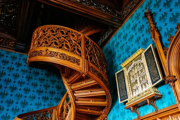 Lednice, Güney Moravya, Çek Cumhuriyeti, 04 Temmuz 2021: Neo-gotik romantik ahşap oymalı mobilyalar, mavi şato kütüphanesinde çiçeklerle süslenmiş dekoratif spiral merdivenler.
