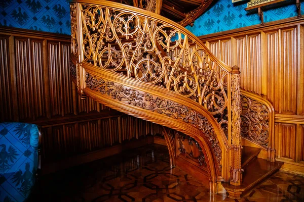 Lednice, Güney Moravya, Çek Cumhuriyeti, 04 Temmuz 2021: Neo-gotik romantik ahşap oymalı mobilyalar, mavi şato kütüphanesinde çiçeklerle süslenmiş dekoratif spiral merdivenler.
