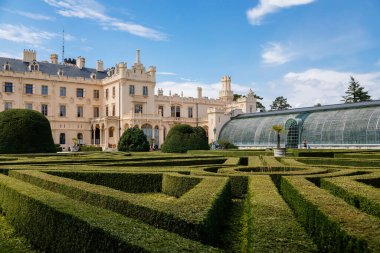 Lednice, Güney Moravya, Çek Cumhuriyeti, 04 Temmuz 2021: Güzel bahçeli şato, güneşli yaz gününde yeşil parklar, neo-gotik romantik kale, geometrik çiçek yatağı, Lednice Valtice Peyzajı.