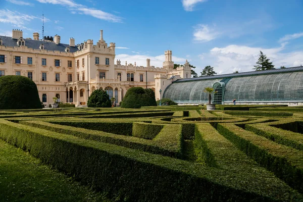 Lednice, Güney Moravya, Çek Cumhuriyeti, 04 Temmuz 2021: Güzel bahçeli şato, güneşli yaz gününde yeşil parklar, neo-gotik romantik kale, geometrik çiçek yatağı, Lednice Valtice Peyzajı.
