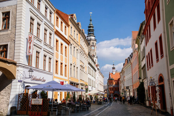 Goerlitz, Saxony, Germany, 04 September 2021: Narrow picturesque street with colorful buildings in historic center in medieval city, renaissance and baroque historical buildings at summer sunny day.