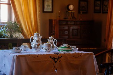 Cervena Lhota, Güney Bohemya, Çek Cumhuriyeti, 9 Ekim 2021: Kale içi, barok ahşap mobilya, misafir salonu, masada porselen çay servisi, pencerenin karşısındaki sandalyeler, tablolar