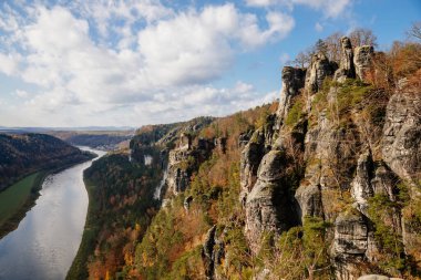 Sakson İsviçre Ulusal Parkı, Almanya, 6 Kasım 2021: Elbe Nehri Vadisi 'nde Basteiaussicht veya Bastei Kaya oluşumları, Kum Dağı Yolu, güneşli bir günde sonbahar ormanı manzarası, kayalık vadi 