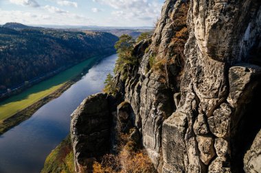Sakson İsviçre Ulusal Parkı, Almanya, 6 Kasım 2021: Elbe Nehri Vadisi 'nde Basteiaussicht veya Bastei Kaya oluşumları, Kum Dağı Yolu, güneşli bir günde sonbahar ormanı manzarası, kayalık vadi 