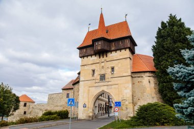 Louny, Çek Cumhuriyeti, 19 Eylül 2021: Duvarı ve prizmatik kaleleri olan Zatec Kapısı, sonbahar günü çatısı altında ahşap koridor bulunan ortaçağ takviye kompleksi, ön cephede Latince yazılar