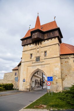 Louny, Çek Cumhuriyeti, 19 Eylül 2021: Duvarı ve prizmatik kaleleri olan Zatec Kapısı, sonbahar günü çatısı altında ahşap koridor bulunan ortaçağ takviye kompleksi, ön cephede Latince yazılar