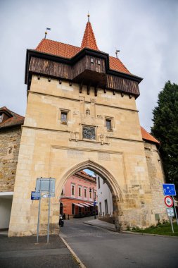 Louny, Çek Cumhuriyeti, 19 Eylül 2021: Duvarı ve prizmatik kaleleri olan Zatec Kapısı, sonbahar günü çatısı altında ahşap koridor bulunan ortaçağ takviye kompleksi, ön cephede Latince yazılar