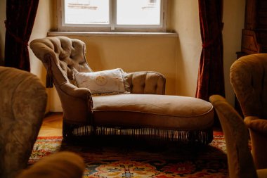 Libochovice, Bohemya, Çek Cumhuriyeti, 19 Eylül 2021: Barok ahşap mobilyalı kale iç mimarisi, yüksek arkası pencere kenarlı yumuşak şezlong, nakışlı yastık