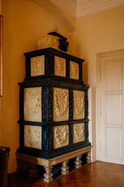 Libochovice, Bohemya, Çek Cumhuriyeti, 19 Eylül 2021: Barok ahşap oymalı mobilyalar, çiçek süslemeli siyah beyaz seramik ocak