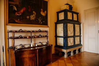 Libochovice, Bohemya, Çek Cumhuriyeti, 19 Eylül 2021: Barok ahşap oymalı mobilyalar, çiçek süslemeli siyah beyaz seramik ocak, bulaşık için dolap ve servis edilen servis