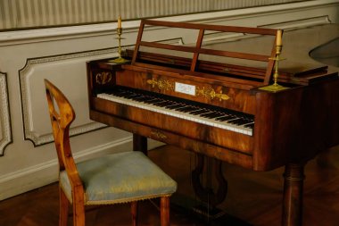 Libochovice, Bohemya, Çek Cumhuriyeti, 19 Eylül 2021: Barok ahşap mobilya, müzik salonu, antika büyük piyano, klasik Biedermeier yeşil sandalyeleri, iki yaldızlı şamdan