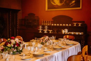 Libochovice, Bohemya, Çek Cumhuriyeti, 19 Eylül 2021: Barok ahşap mobilya, yemek odası, porselen ve kristal bardaklı masa, tabak için dolap, çiçekli vazolar