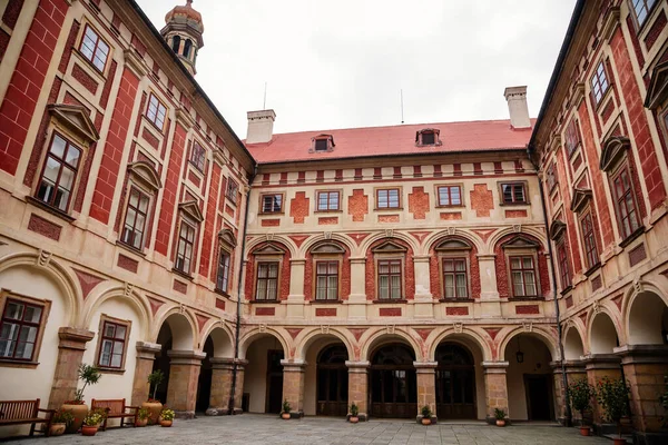 Libochovice, Bohemya, Çek Cumhuriyeti, 19 Eylül 2021: Fransız tarzı park ve bahçeli kale, Romantik kırmızı ve sarı barok şato, sonbahar günü atari salonlu avlu, seramik kaplarda bitkiler