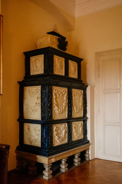 Libochovice, Bohemya, Çek Cumhuriyeti, 19 Eylül 2021: Barok ahşap oymalı mobilyalar, çiçek süslemeli siyah beyaz seramik ocak