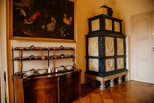 Libochovice, Bohemya, Çek Cumhuriyeti, 19 Eylül 2021: Barok ahşap oymalı mobilyalar, çiçek süslemeli siyah beyaz seramik ocak, bulaşık için dolap ve servis edilen servis