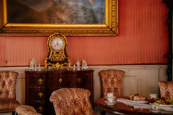 Libochovice, Bohemia, Çek Cumhuriyeti, 19 Eylül 2021: Barok ahşap mobilyalar, çekmeceli şifoniyerde altın kaplama antika saat, duvarda altın çerçeveli resim