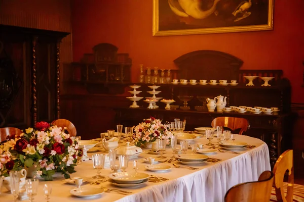 Libochovice, Bohemya, Çek Cumhuriyeti, 19 Eylül 2021: Barok ahşap mobilya, yemek odası, porselen ve kristal bardaklı masa, tabak için dolap, çiçekli vazolar