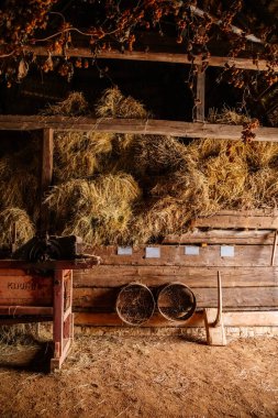 Kourim, Czech Republic, 26 December 2021: Inside rustic wooden old barn hay, Attic of hayloft, Bales dry straw, light beams farm, village rural lifestyle background, open-air ethnographic museum