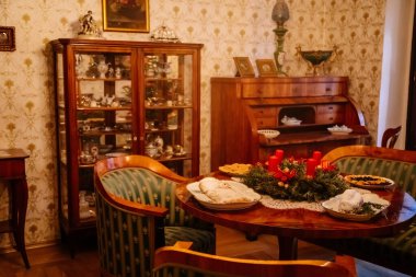 Kolin, Çek Cumhuriyeti, 26 Aralık 2021: Bölgesel Müze Binası Cervinkovsky dum, Biedermeier tarzı mobilyalar, ahşap masa, masanın yanındaki kolay sandalye ve kanepe, çerçeveli dikey ayna aynası