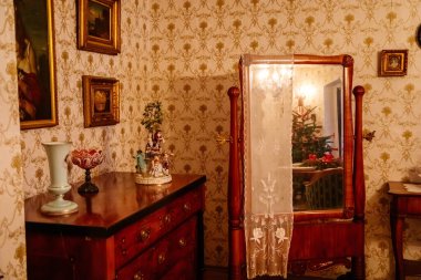 Kolin, Çek Cumhuriyeti, 26 Aralık 2021: Bölgesel Müze Binası Cervinkovsky dum, Biedermeier tarzı mobilyalar, ahşap masa, masanın yanındaki kolay sandalye ve kanepe, çerçeveli dikey ayna aynası