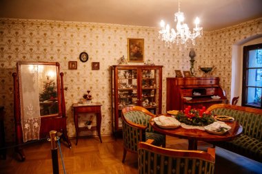 Kolin, Çek Cumhuriyeti, 26 Aralık 2021: Bölgesel Müze Binası Cervinkovsky dum, Biedermeier tarzı mobilyalar, ahşap masa, masanın yanındaki kolay sandalye ve kanepe, çerçeveli dikey ayna aynası