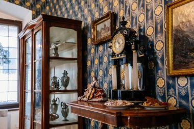 Kolin, Çek Cumhuriyeti, 26 Aralık 2021: Bölgesel Müze Evi Cervinkovsky dum, Biedermeier tarzı mobilya, rafta antika saat, altın çerçeveli tablolar, mavi duvarlar