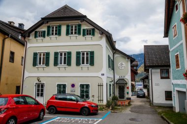 Hallstatt, Avusturya, 27 Ağustos 2021: Yaz günü renkli manzaralı bir kasaba sokağı, göl ve Alpler yakınlarındaki dağ köyü, UNESCO mirası, geleneksel evler, ahşap balkonlar, saksılarda çiçekler