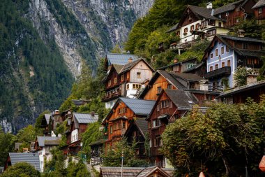 Hallstatt, Avusturya, 27 Ağustos 2021: Yaz günü renkli manzaralı bir kasaba sokağı, göl ve Alpler yakınlarındaki dağ köyü, UNESCO mirası, geleneksel evler, ahşap balkonlar, saksılarda çiçekler