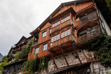 Hallstatt, Avusturya, 27 Ağustos 2021: Yaz günü renkli manzaralı bir kasaba sokağı, göl kenarındaki dağ köyü, Alpler, UNESCO mirası, balkonlu geleneksel ahşap evler, saksılarda çiçekler