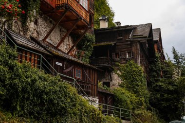 Hallstatt, Avusturya, 27 Ağustos 2021: Yaz günü renkli manzaralı bir kasaba sokağı, göl kenarındaki dağ köyü, Alpler, UNESCO mirası, balkonlu geleneksel ahşap evler, saksılarda çiçekler