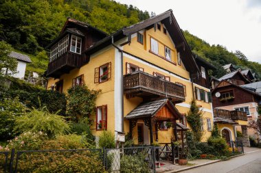 Hallstatt, Avusturya, 27 Ağustos 2021: Yaz günü renkli manzaralı bir kasaba sokağı, göl ve Alpler yakınlarındaki dağ köyü, UNESCO mirası, geleneksel evler, ahşap balkonlar, saksılarda çiçekler