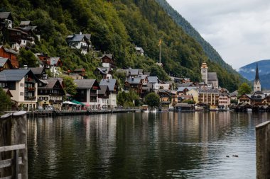 Hallstatt, Avusturya, 27 Ağustos 2021: Yaz günü renkli manzaralı bir kasaba caddesi, Alps 'teki dağ köyü, UNESCO mirası, geleneksel evler, ahşap balkonlar, saksılarda çiçekler, su gölü