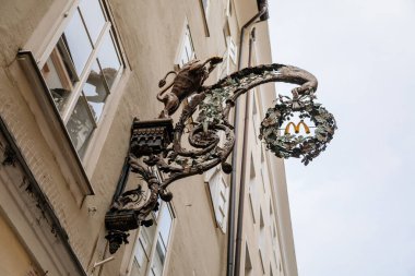 Salzburg, Avusturya, 28 Ağustos 2021: Tarihi Altstadt veya Eski Şehir 'de bulunan ünlü Getreidegasse alışveriş dar caddesi, yaz günü demir lonca tabelaları astı, çok sayıda yüksek konak evi gökyüzüne yükseldi