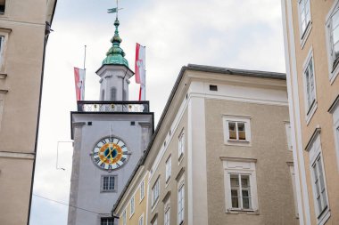 Salzburg, Avusturya, 28 Ağustos 2021: Tarihi Altstadt 'ta Tahıl Şeridi veya Getreidegasse alışveriş dar sokağı, yaz günü demir lonca tabelası, saat kulesi olan Rathaus Eski Belediye Binası