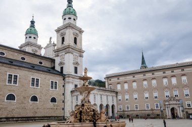 Salzburg, Avusturya, 28 Ağustos 2021: Triton heykeli olan Fountain Residenzbrunnen Domplatz Meydanı 'nda, Barok katedrali yaz günü iki beyaz kuleli, Rönesans Alte Residenz veya Old Residence