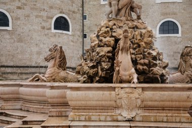 Salzburg, Avusturya, 28 Ağustos 2021: Triton heykeli olan Fountain Residenzbrunnen Domplatz Meydanı 'nda, Barok katedrali yaz günü iki beyaz kuleli, Rönesans Alte Residenz veya Old Residence
