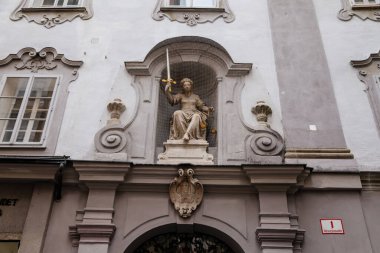 Salzburg, Avusturya, 28 Ağustos 2021: Tarihi Altstadt 'ta Tahıl Şeridi veya Getreidegasse alışveriş dar sokağı, yaz günü demir lonca tabelası, saat kulesi olan Rathaus Eski Belediye Binası