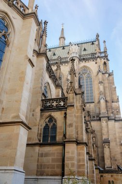 Linz, Avusturya, 27 Ağustos 2021: Kemerli, güneşli yaz gününde eski kasaba caddesi, pencere ve oyma heykellerle Orta Çağ Katolik taş katedrali Yeni Kusursuz Gebelik Katedrali