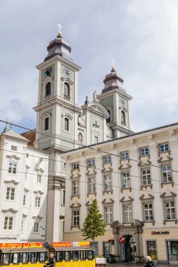 Linz, Avusturya, 27 Ağustos 2021: Barok Eski Katedrali veya iki kulesi olan Alter Dom, Ignatius Kilisesi, Hauptplatz veya güneşli yaz günü ana meydanı, taş renkli tarihi binalar cephesi